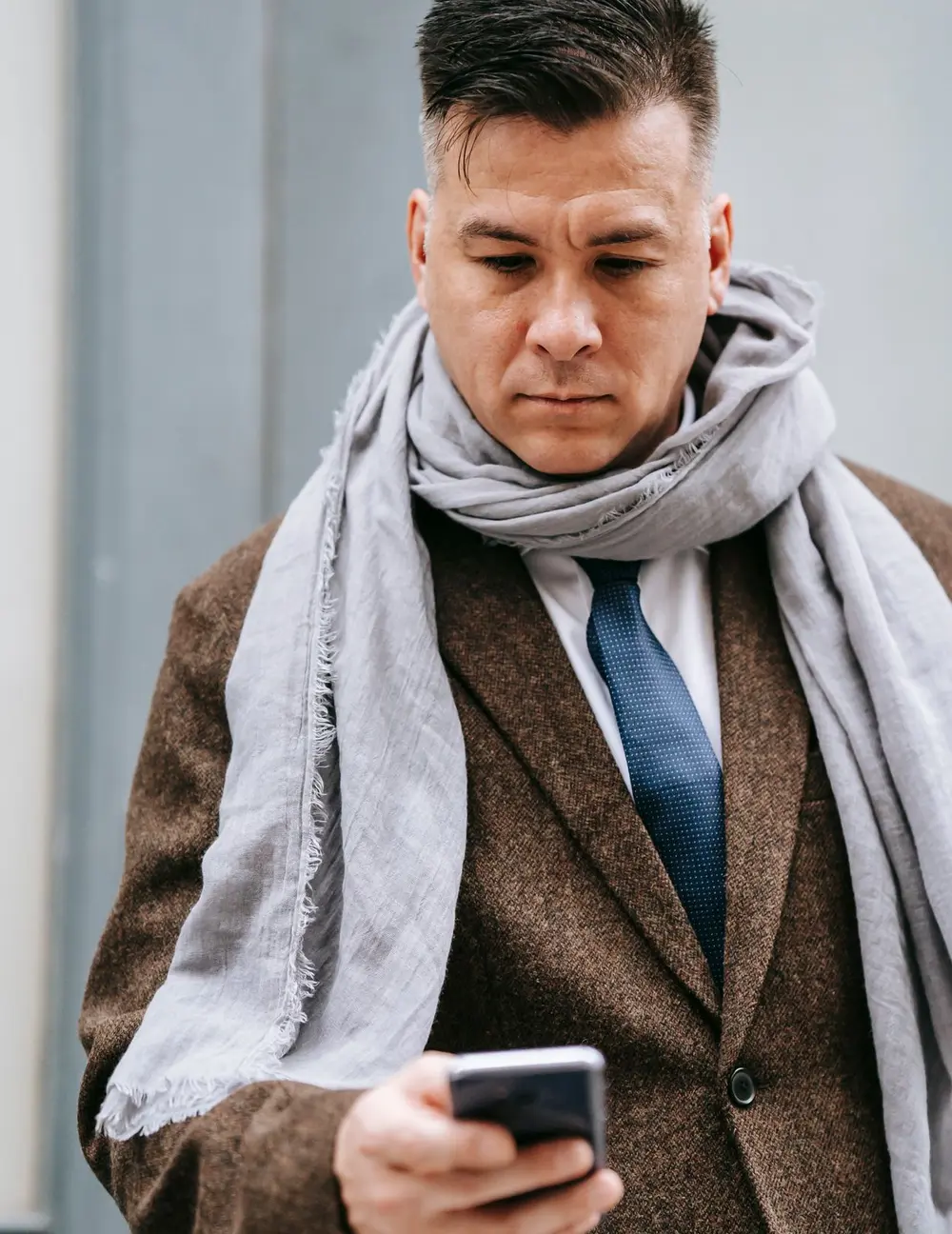 Un commercial lit un message WhatsApp sur son téléphone, dans la rue