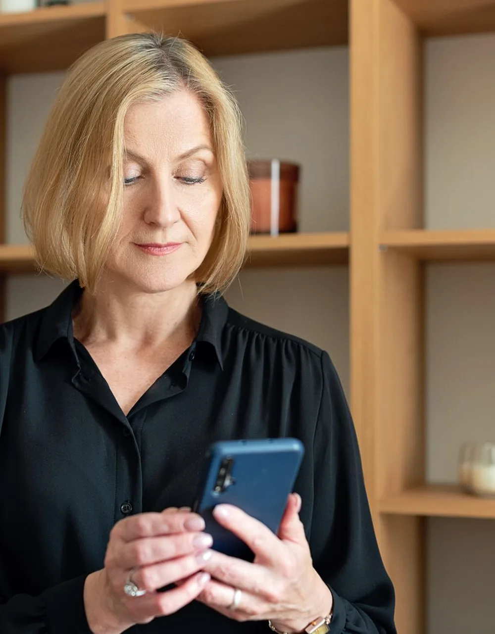 Une gérante de boutique lit un message sur son smartphone