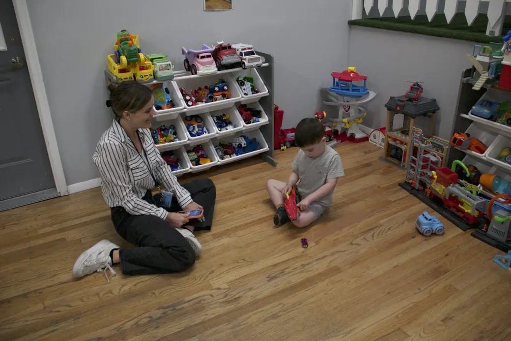 A Black Bear Academy clinician playing one-on-one with a child in the classroom