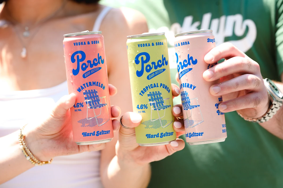 Close-up of three hands holding Porch hard seltzer cans in watermelon, tropical punch, and raspberry flavors.