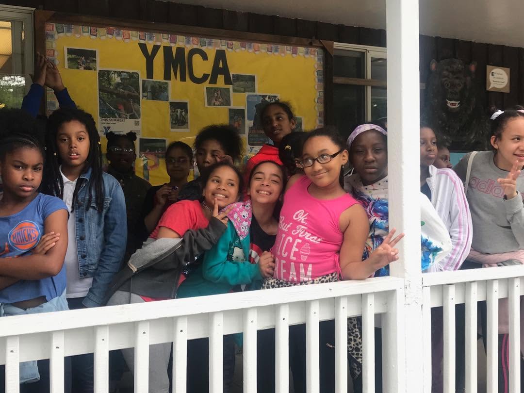 Students smiling together outside a YMCA building