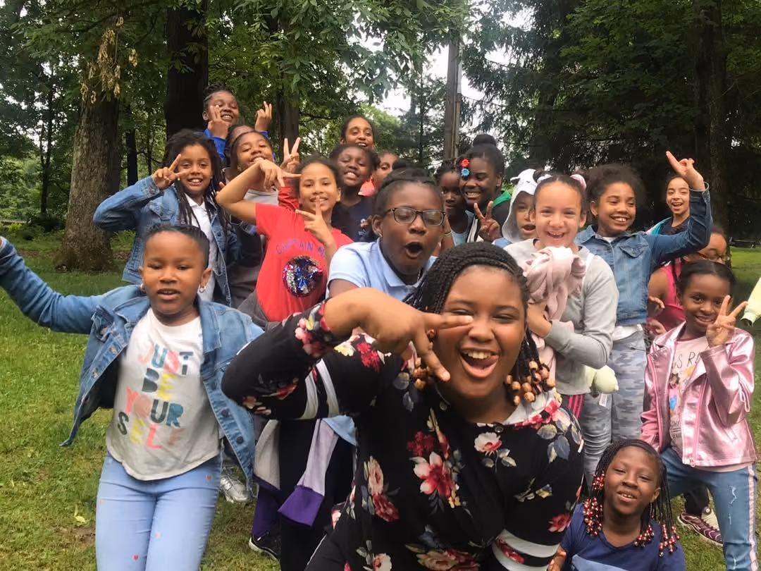 Students smiling and posing outdoors during a school field trip
