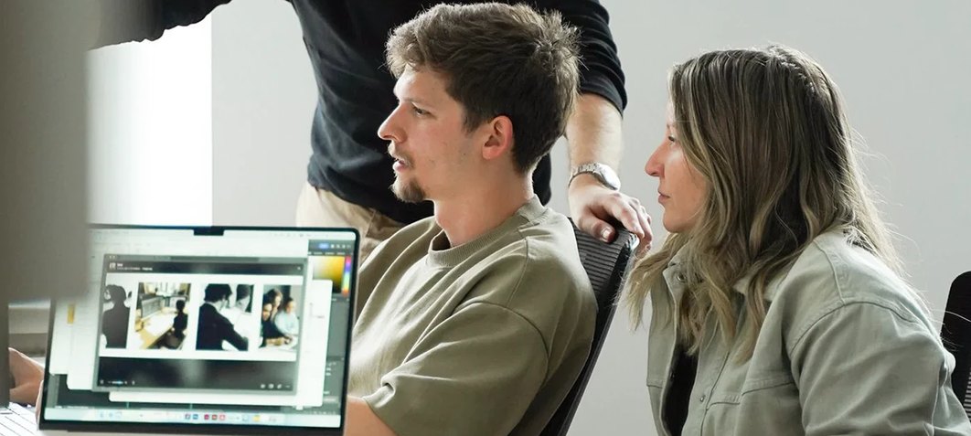 Colleagues discussing work in front of a laptop