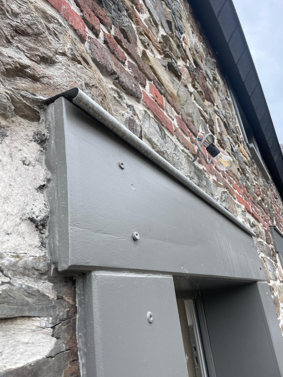 Détail d’un zinc de protection posé au-dessus d’un ébrasement de châssis à Stavelot