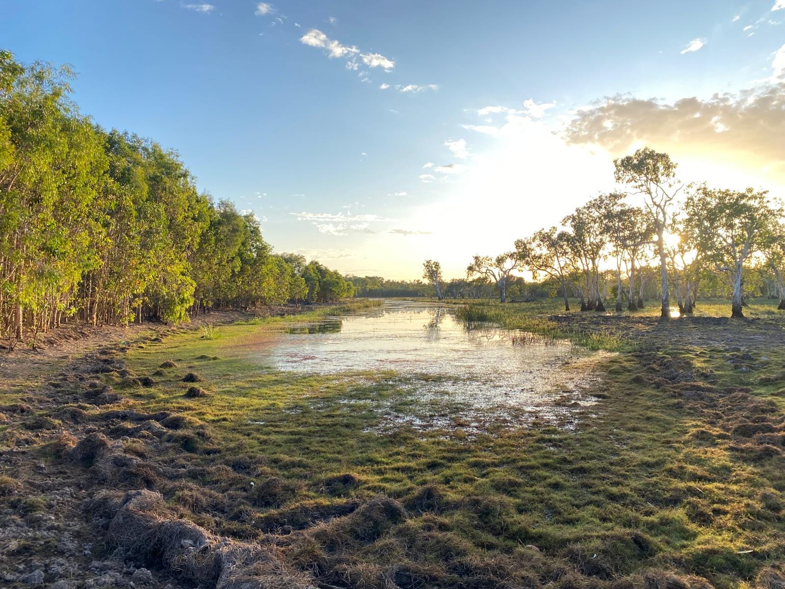 Water spreading across an open floodplain at sundown