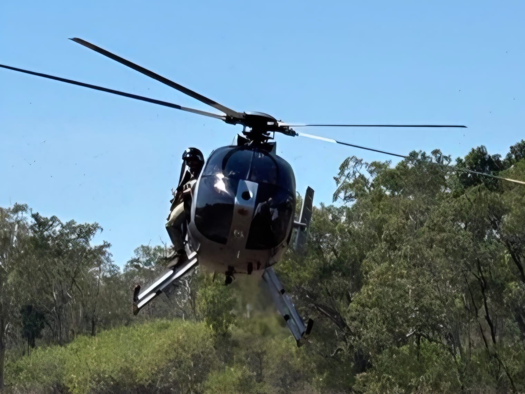 Helicopter working low over the treeline