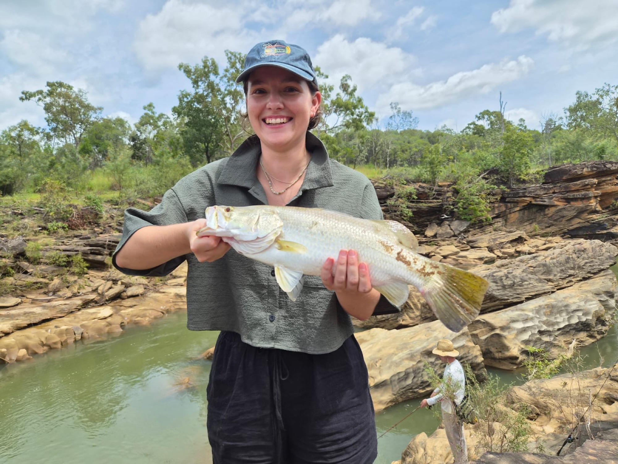 An angler with a barramundi caught at a rock bar