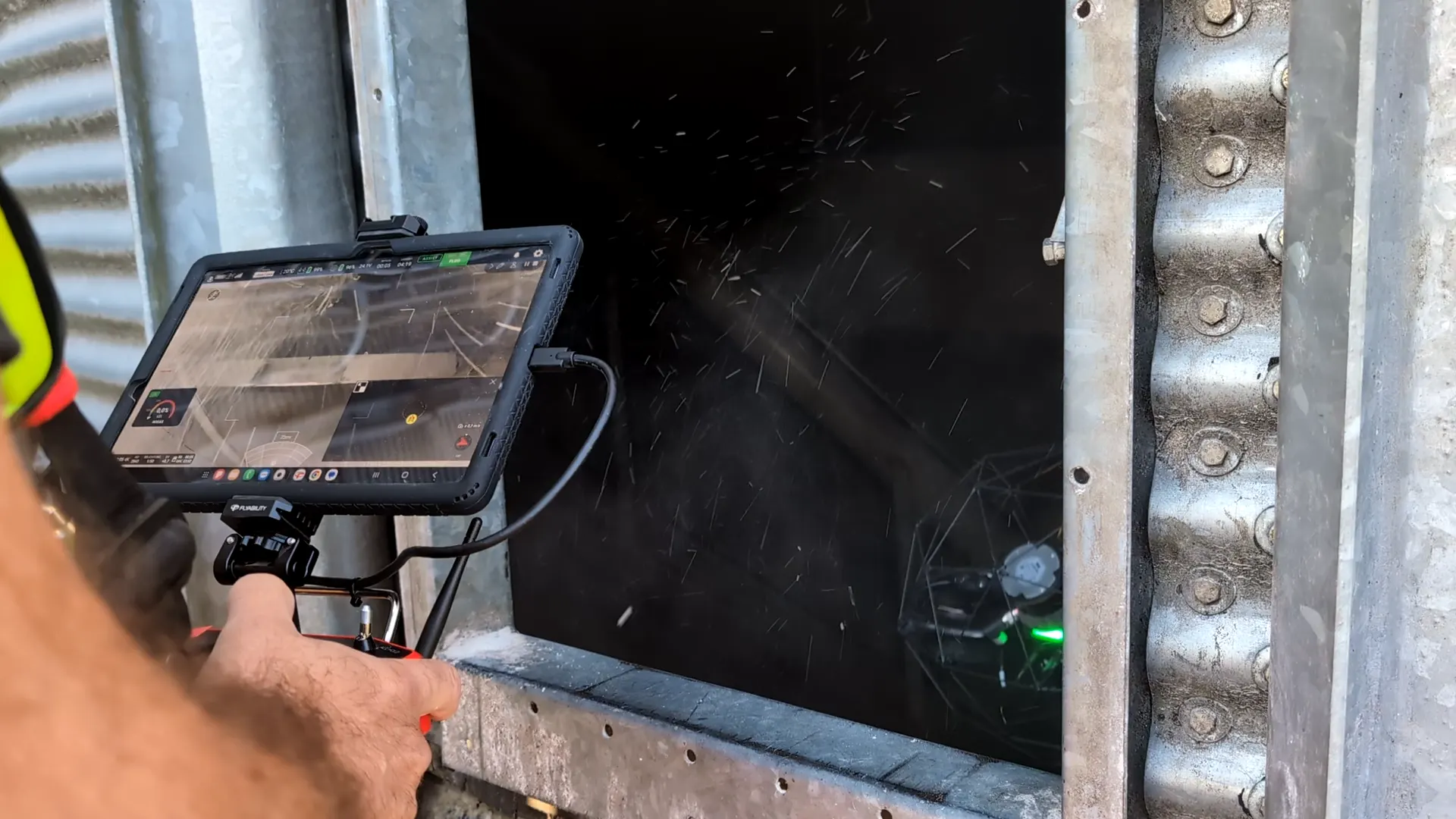 Pilot steuert die Drohne per Tablet durch eine Öffnung in einen Silo