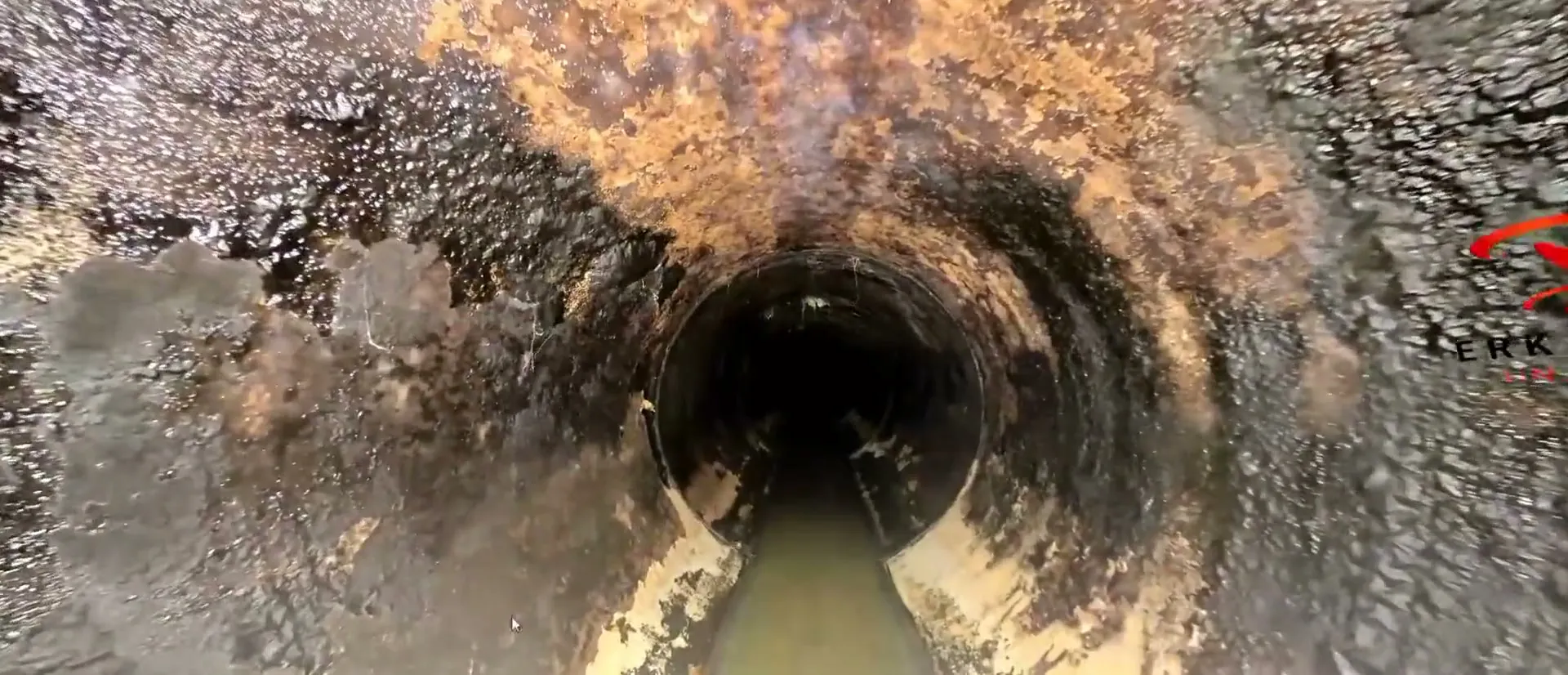 Blick durch einen korrodierten Kanal mit Wasserlauf, aufgenommen mit 360°-Kamera