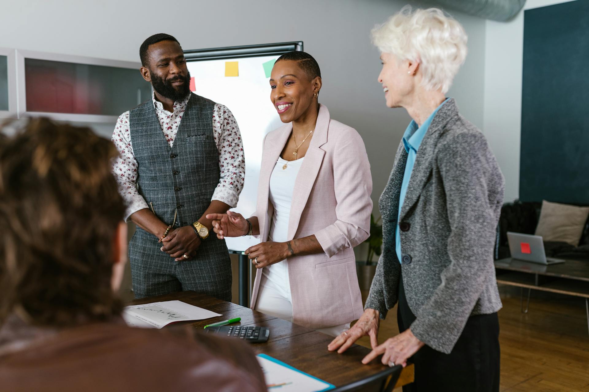 A meeting between four employees standing around a table