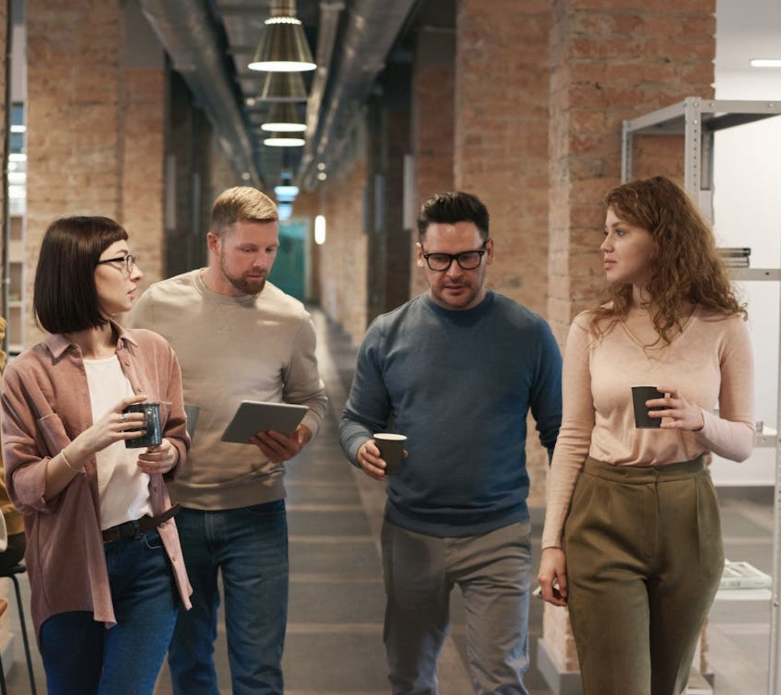 A team having a discussion while walking in the office.