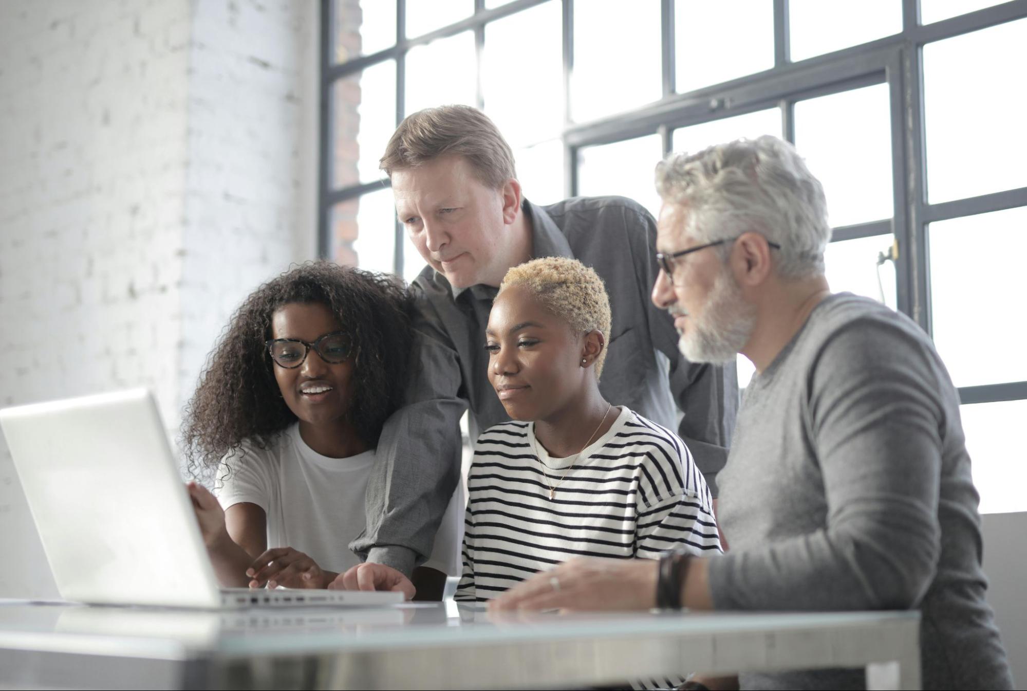  A group of HR professionals reviewing employee data together on a laptop.