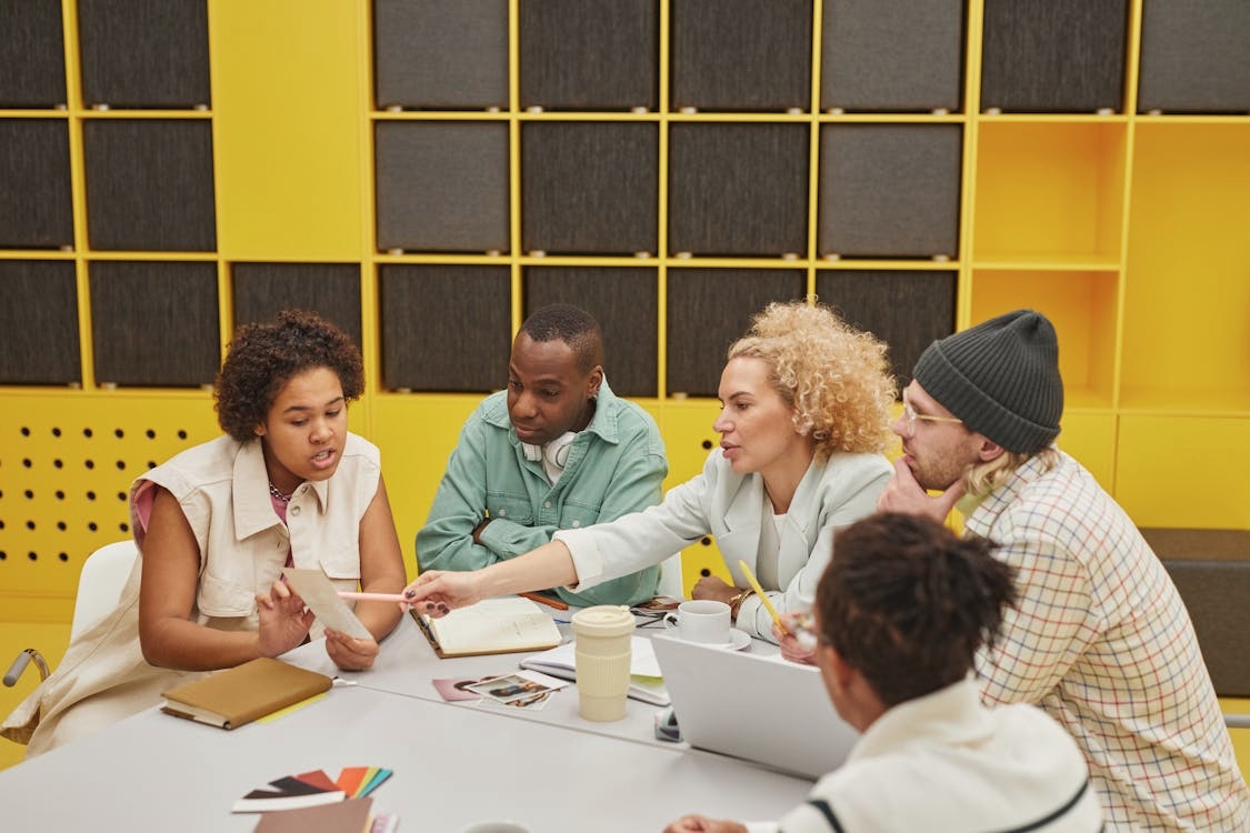A group of office workers discussing a document during a meeting.