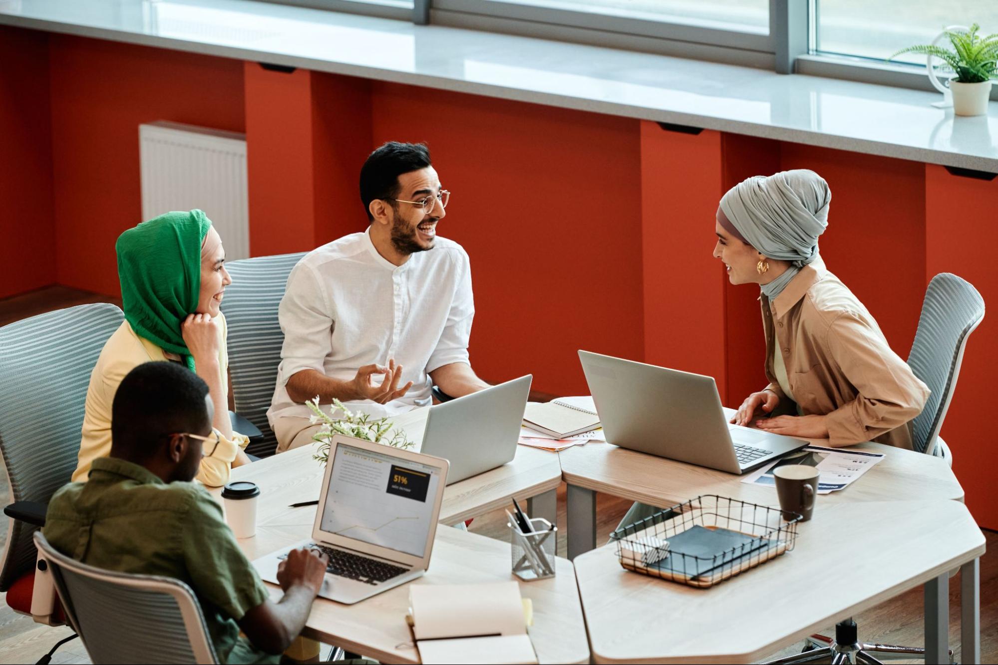 A group of people having a meeting over laptops in an office.
