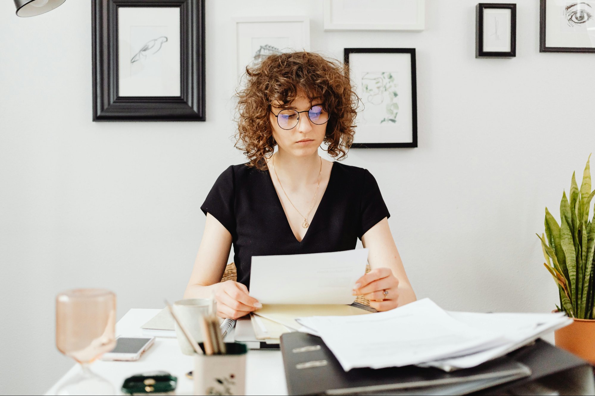 A person examining a document at an office desk.