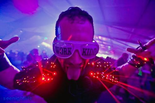 Kidd Madonny wearing light-up glasses saying 'WORK KIDD' and a glowing jacket with red lights.