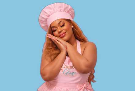 Crumb & Glaze baker resting hands under her cheek, against a soft blue background