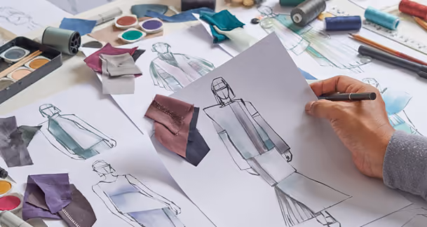 Fashion sketches, fabric samples, and a designer drawing