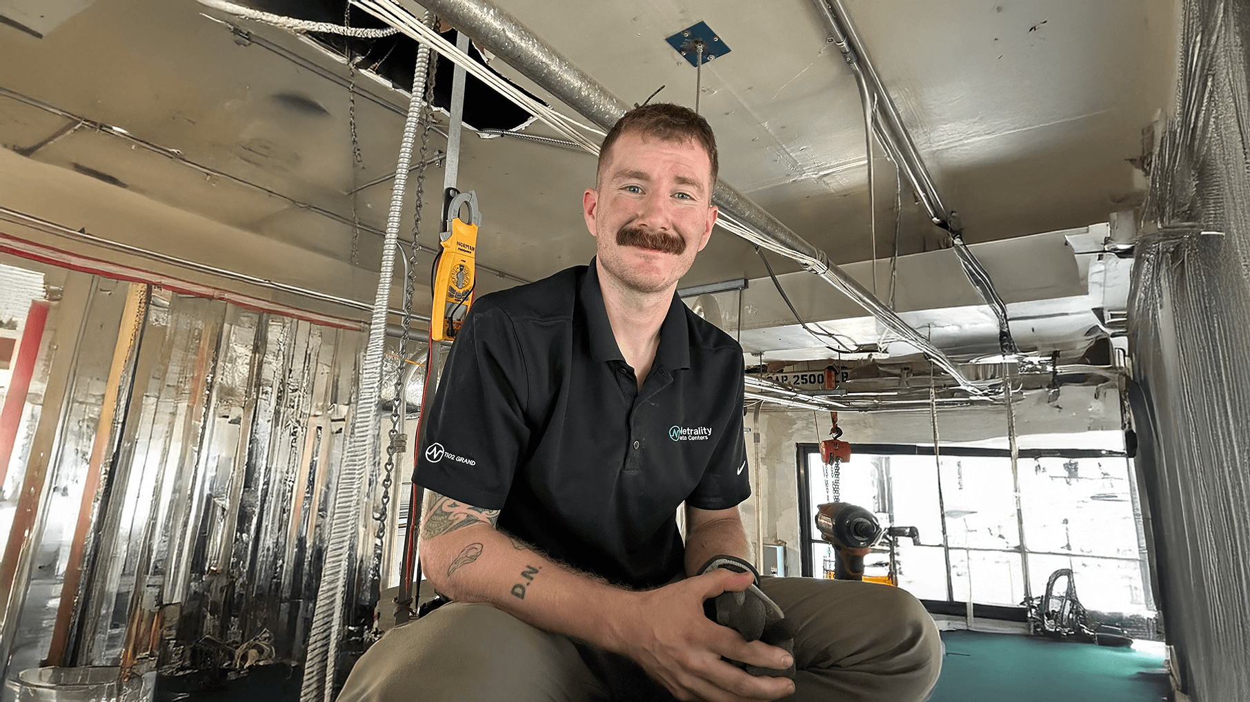 Dylan Norman, the founder of American Air purification, sitting at a job site with troubleshooting tools around.