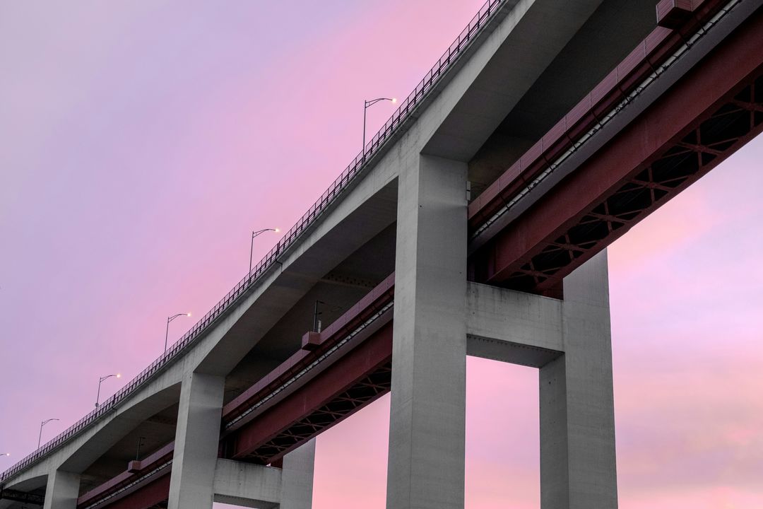 A concrete bridge against a pink evening sky
