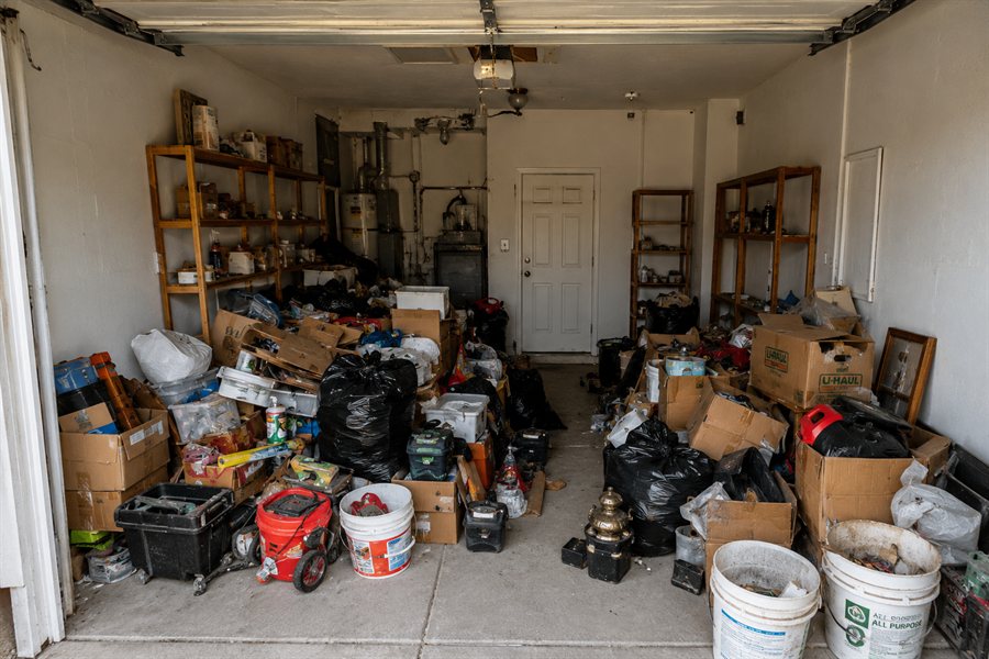 Garage packed floor to ceiling with boxes, bags and old equipment before junk removal