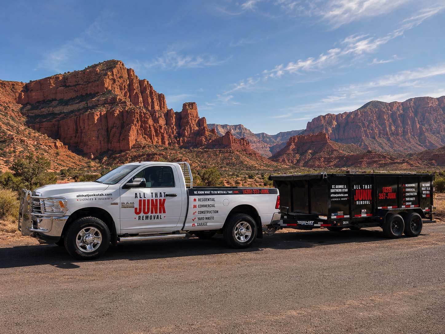 All That Junk Removal pickup truck towing a black dump trailer, parked on a gravel road in front of Southern Utah red rock cliffs