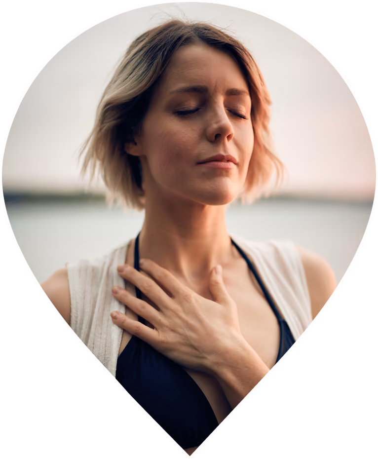 Woman with eyes closed and hand resting on her chest in a calm, grounding moment