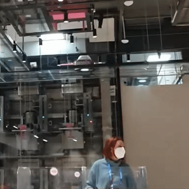 Colleague in a face mask inside the glass-walled Beijing venue