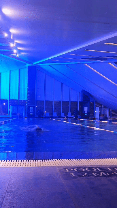Indoor swimming pool lit in blue