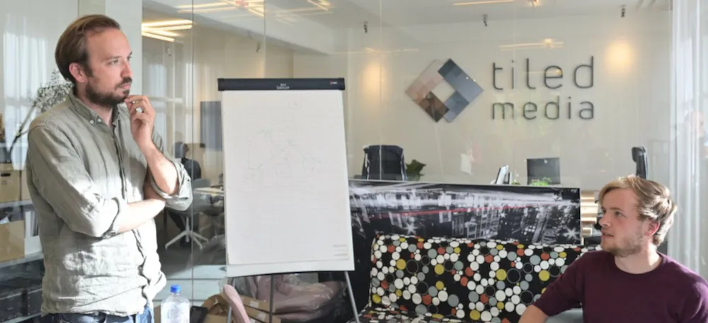 Two colleagues at a whiteboard in the Tiledmedia office