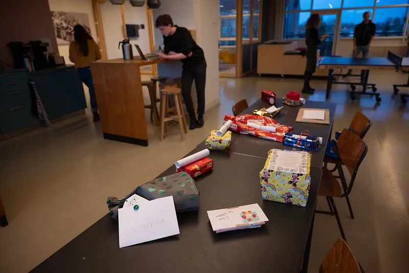 Office tables covered with Sinterklaas presents and wrapping paper