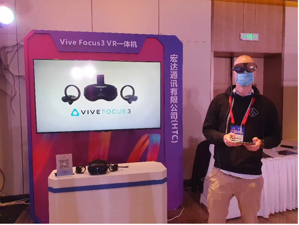 Colleague beside a Vive Focus 3 display stand at a Chinese trade show