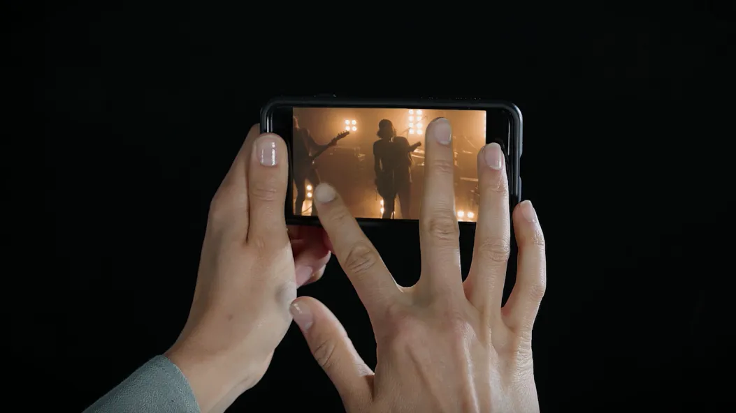 Hands zooming in on a phone showing a VR video