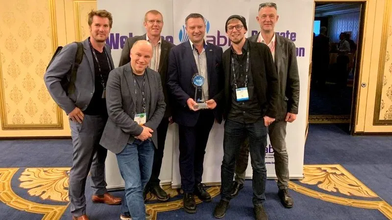 Team accepting the IABM award on stage in Las Vegas