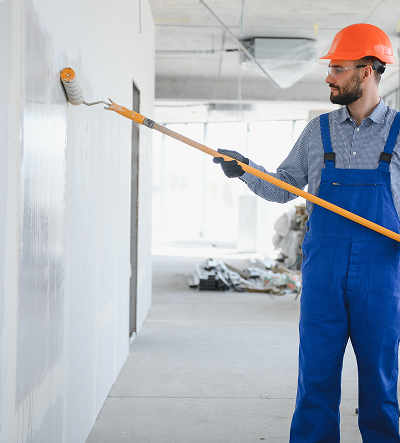 professional painter using a roller brush to paint a white wall