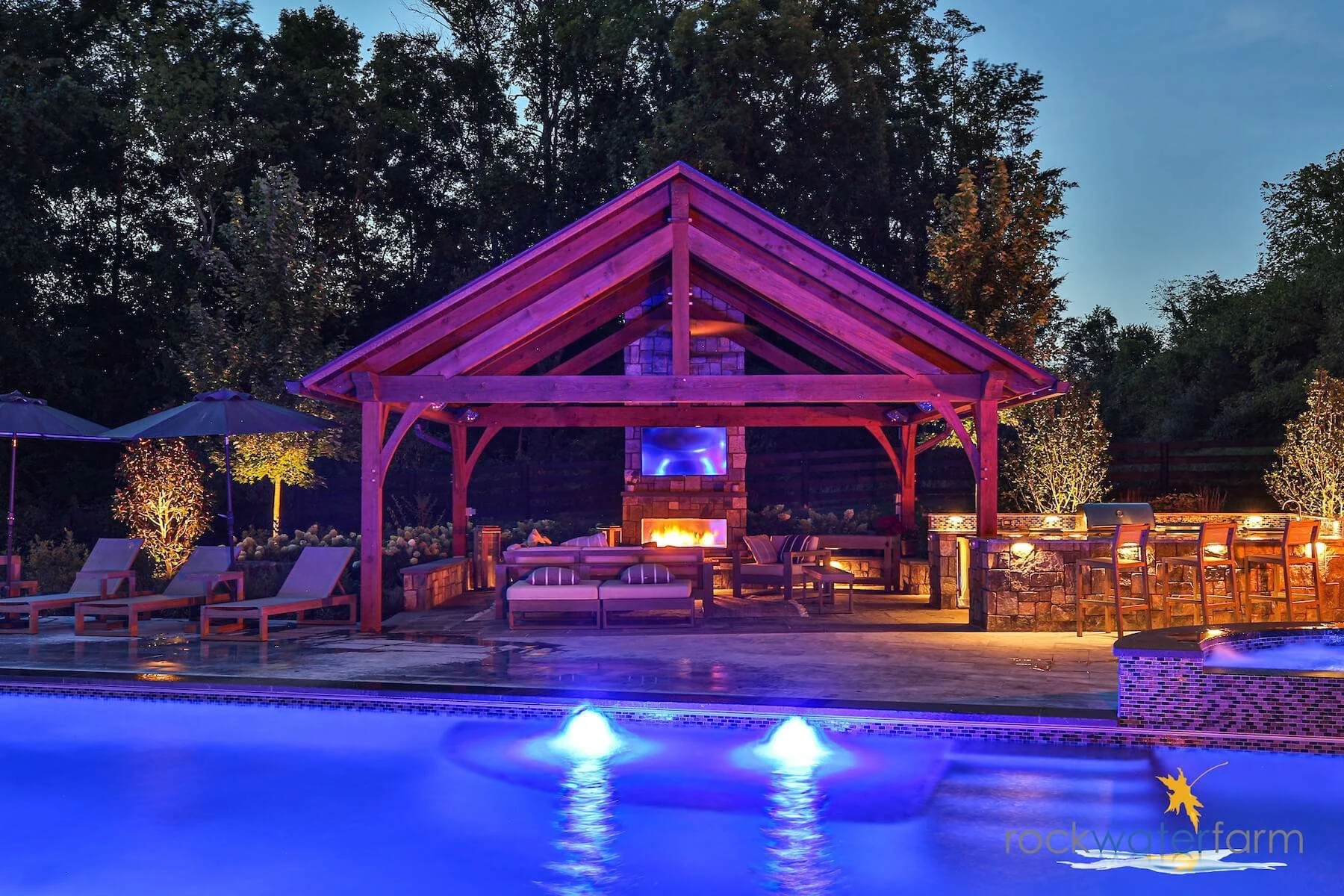 Outdoor pool and covered entertainment area with integrated lighting, audio, and video