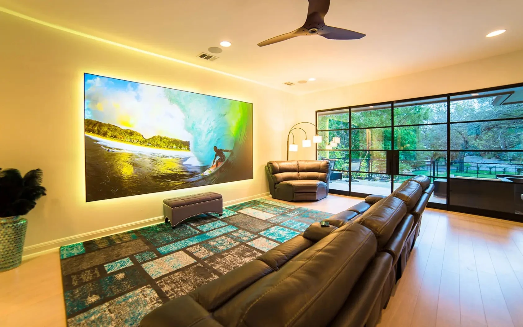 Residential media room with large display, seating, lighting, and integrated audio