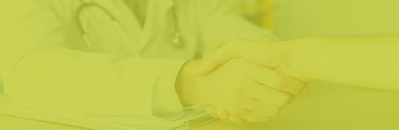 Doctor and patient shaking hands over a care plan
