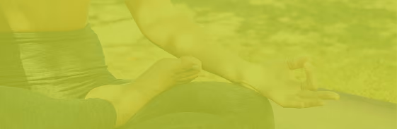 Person meditating cross-legged outdoors