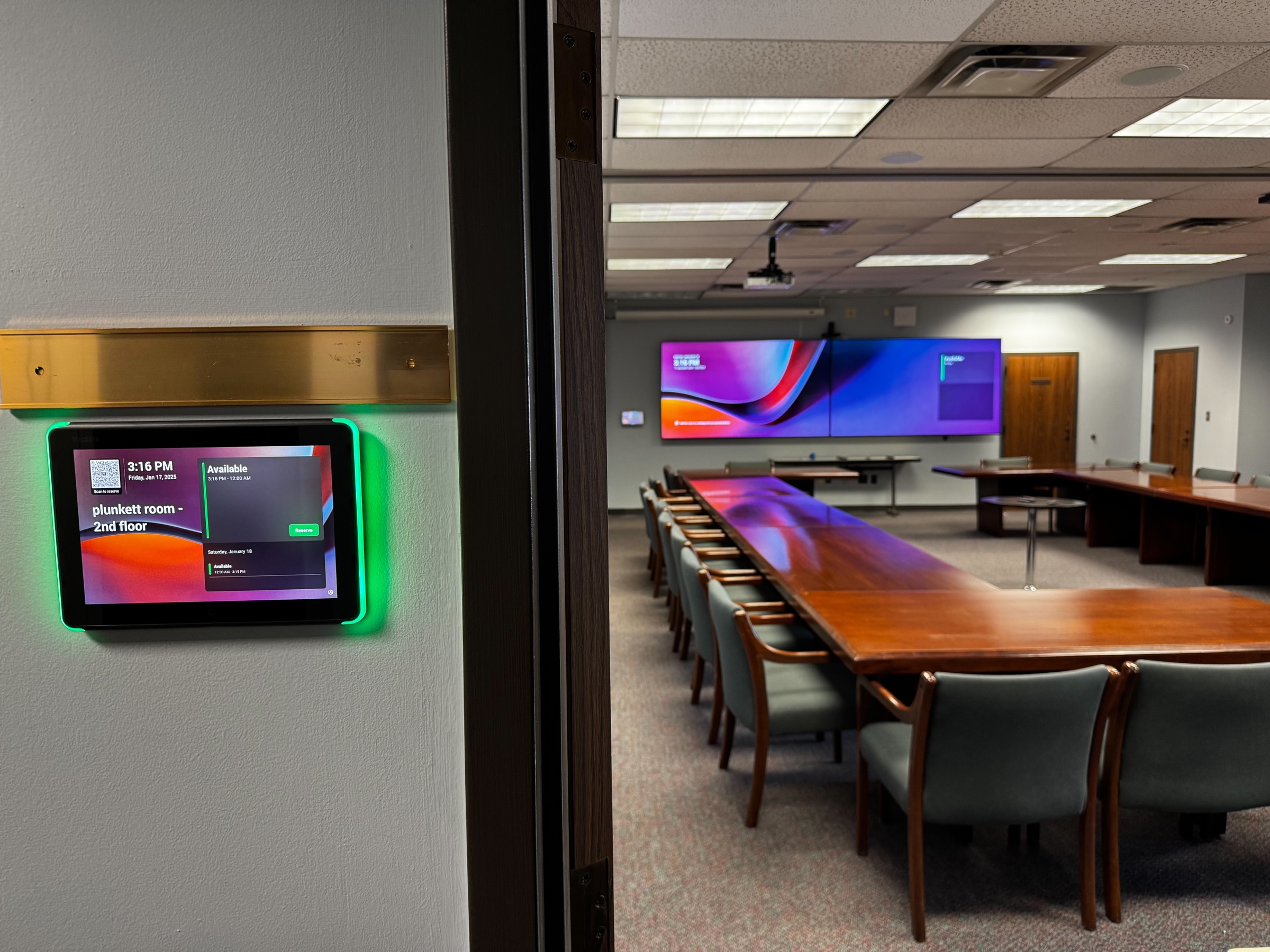 Yealink room scheduler outside SREB’s Plunkett training room with dual displays visible inside