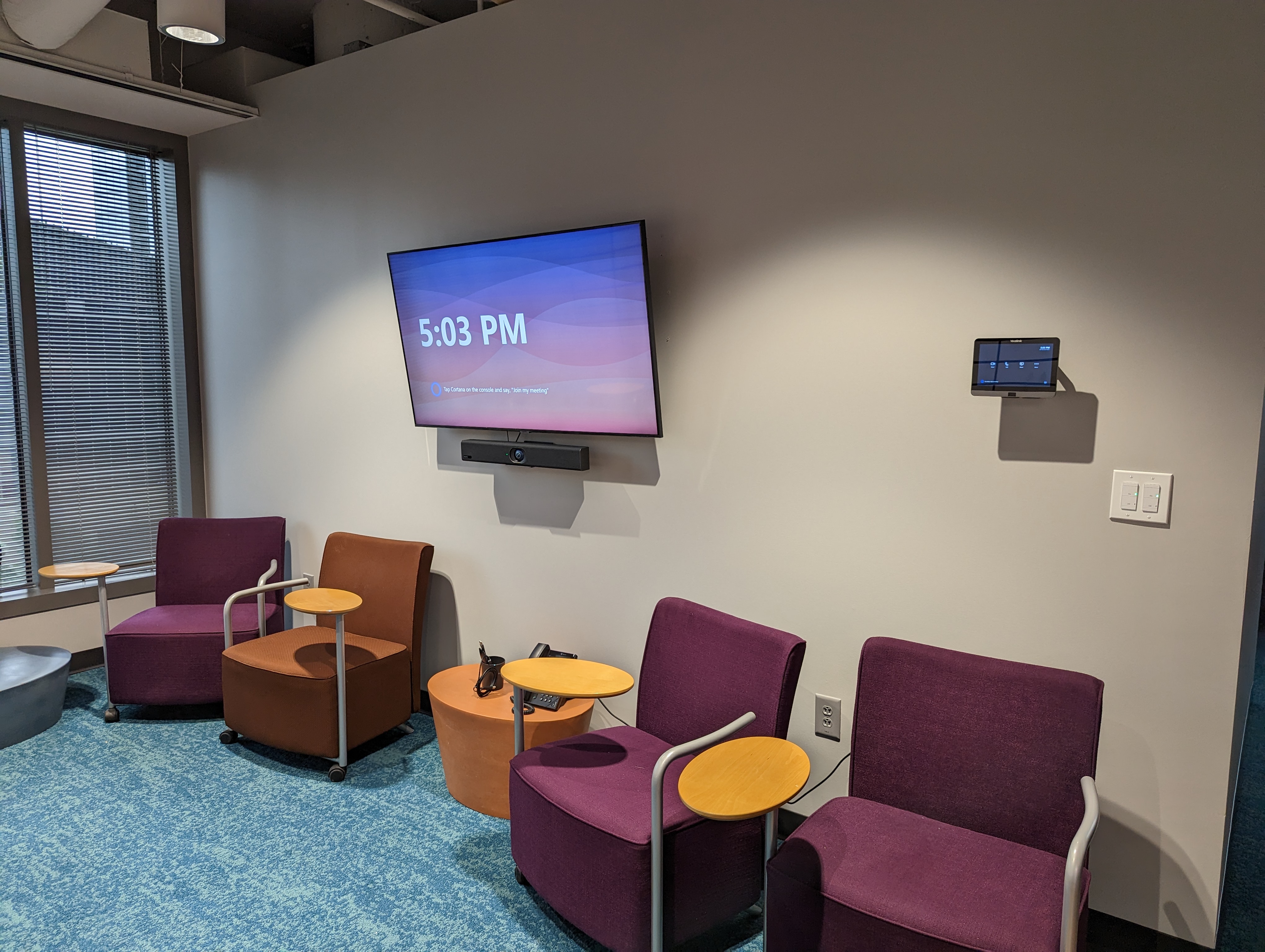 Small Brunner meeting room with a display, Yealink video bar, and wall-mounted touch controller