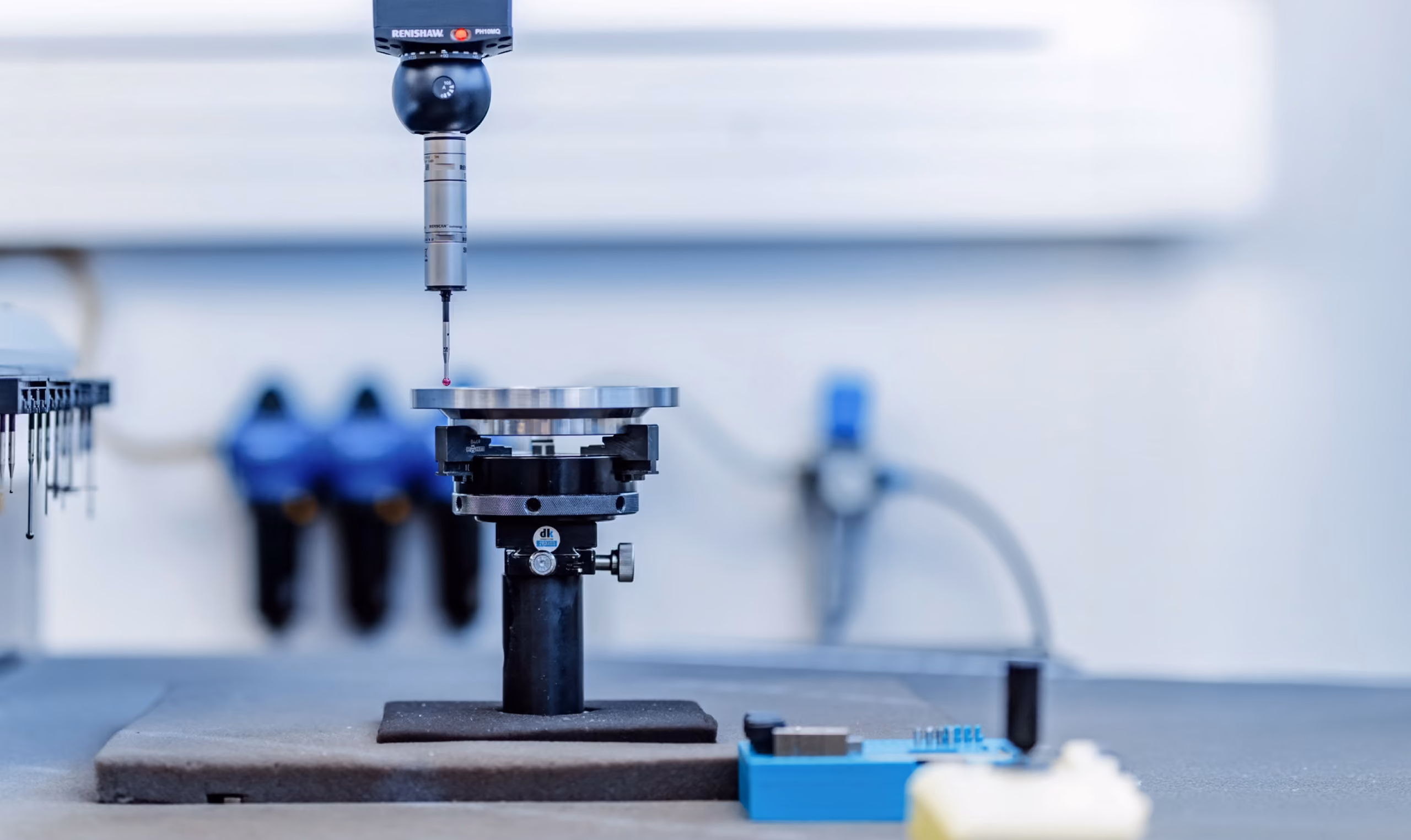 Präzisionsmessgerät von Renishaw misst eine runde Metallplatte auf einem Prüfstand.