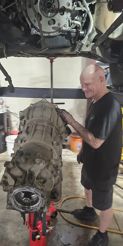 Certified technician servicing a transmission in the Top Notch Fort Worth shop