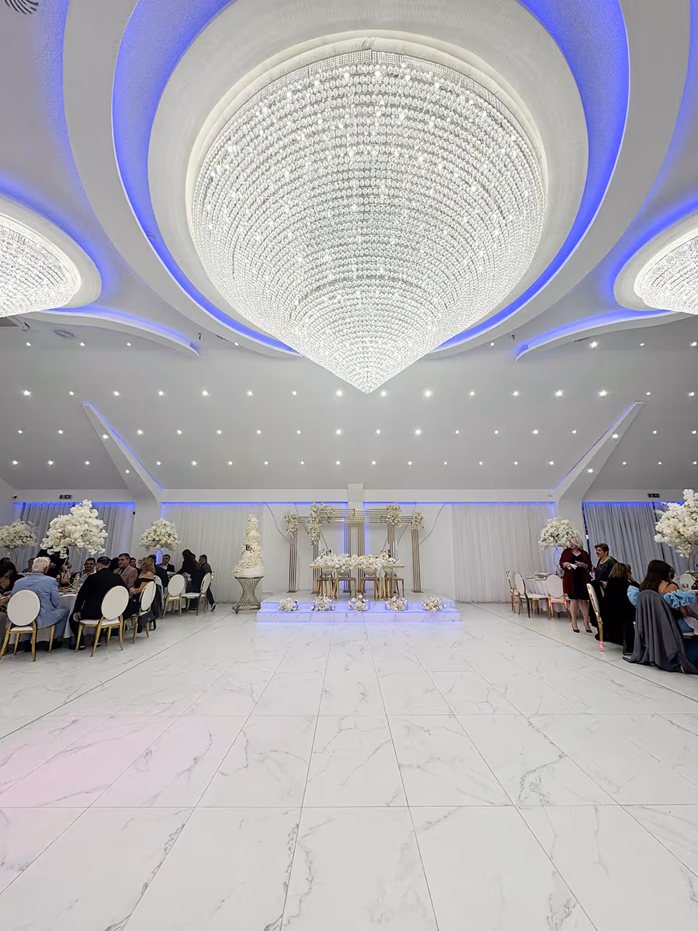 Interieur van Arian Feestzaal met kroonluchters en ronde tafels