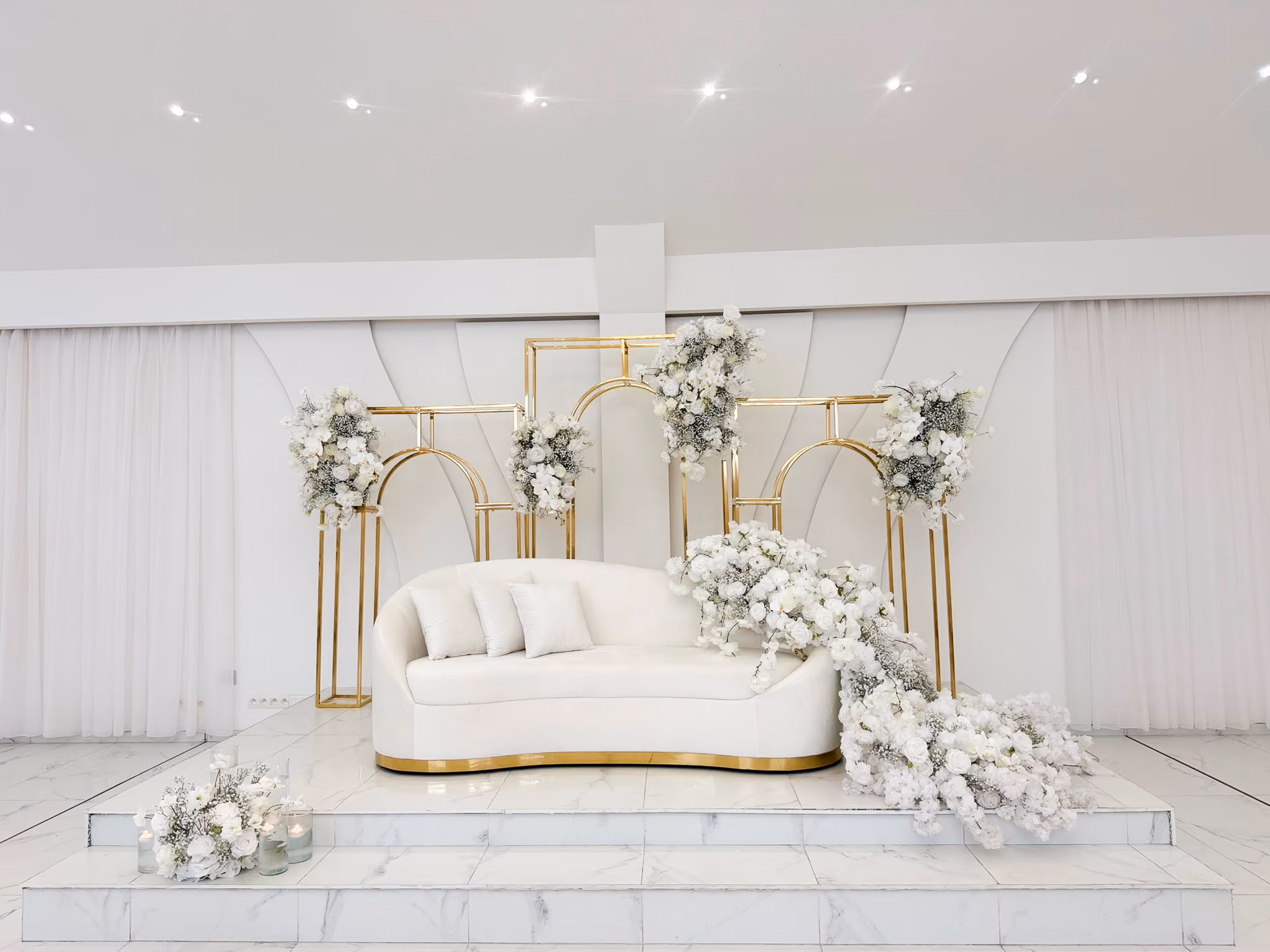 Luxe trouwpodium met witte en gouden decoratie