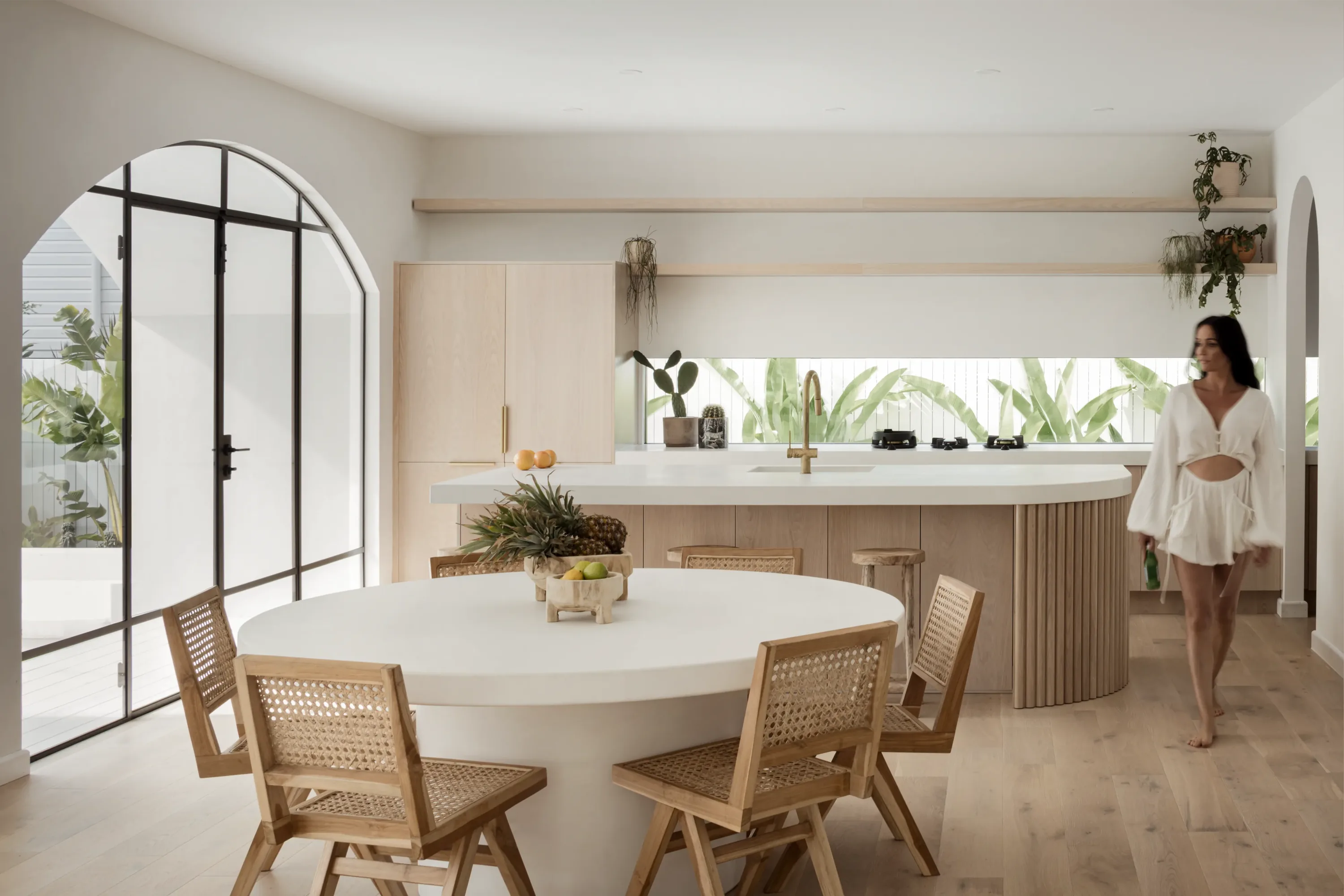 Light-filled Gold Coast home with a curved kitchen island, timber cabinetry and dining area