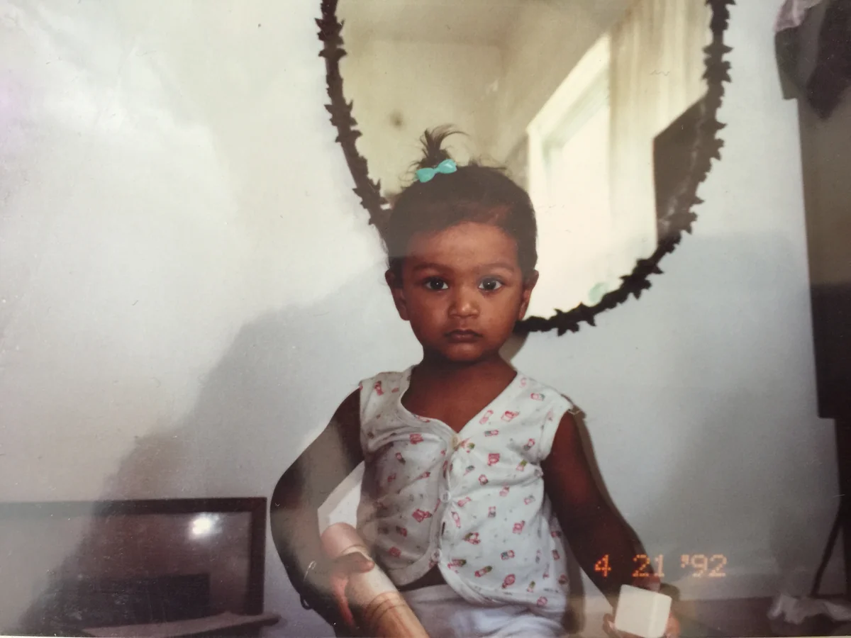 Souvid JIJO Datta as a young child, wearing a turquoise hair bow and a patterned outfit.