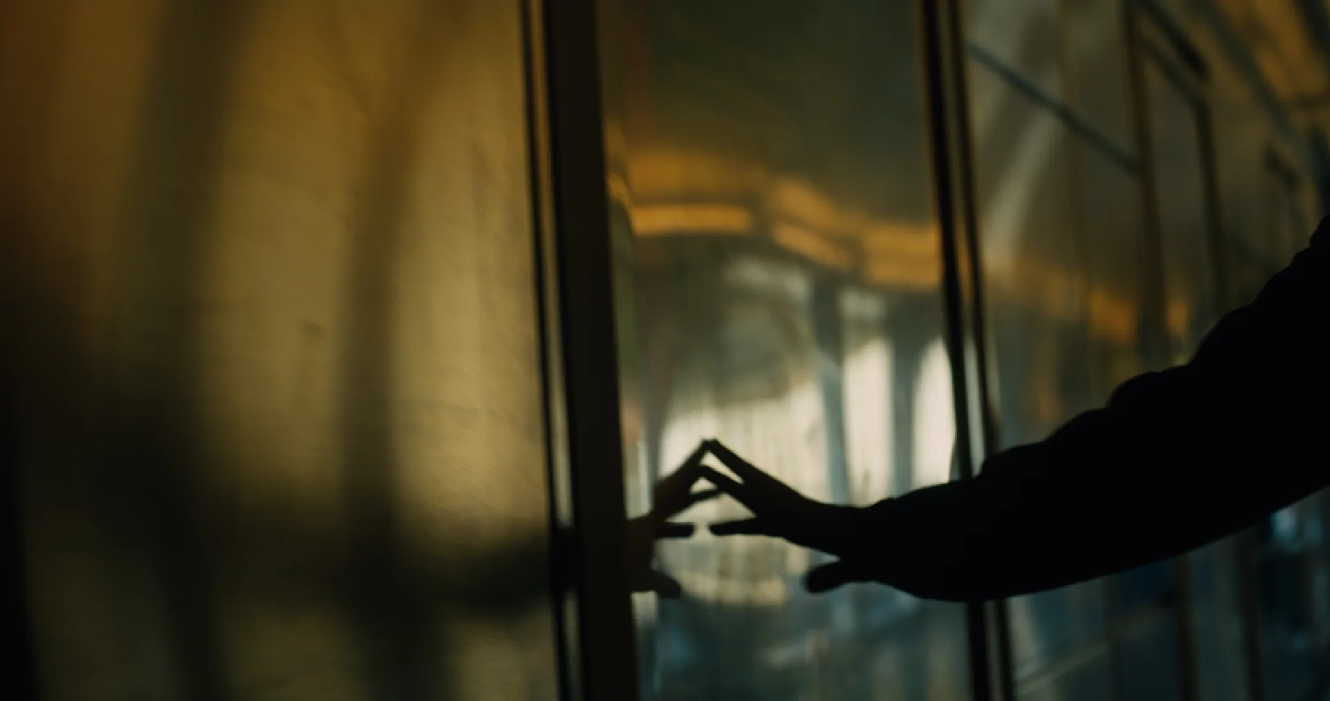 Not Yet — A hand catching the light at a window