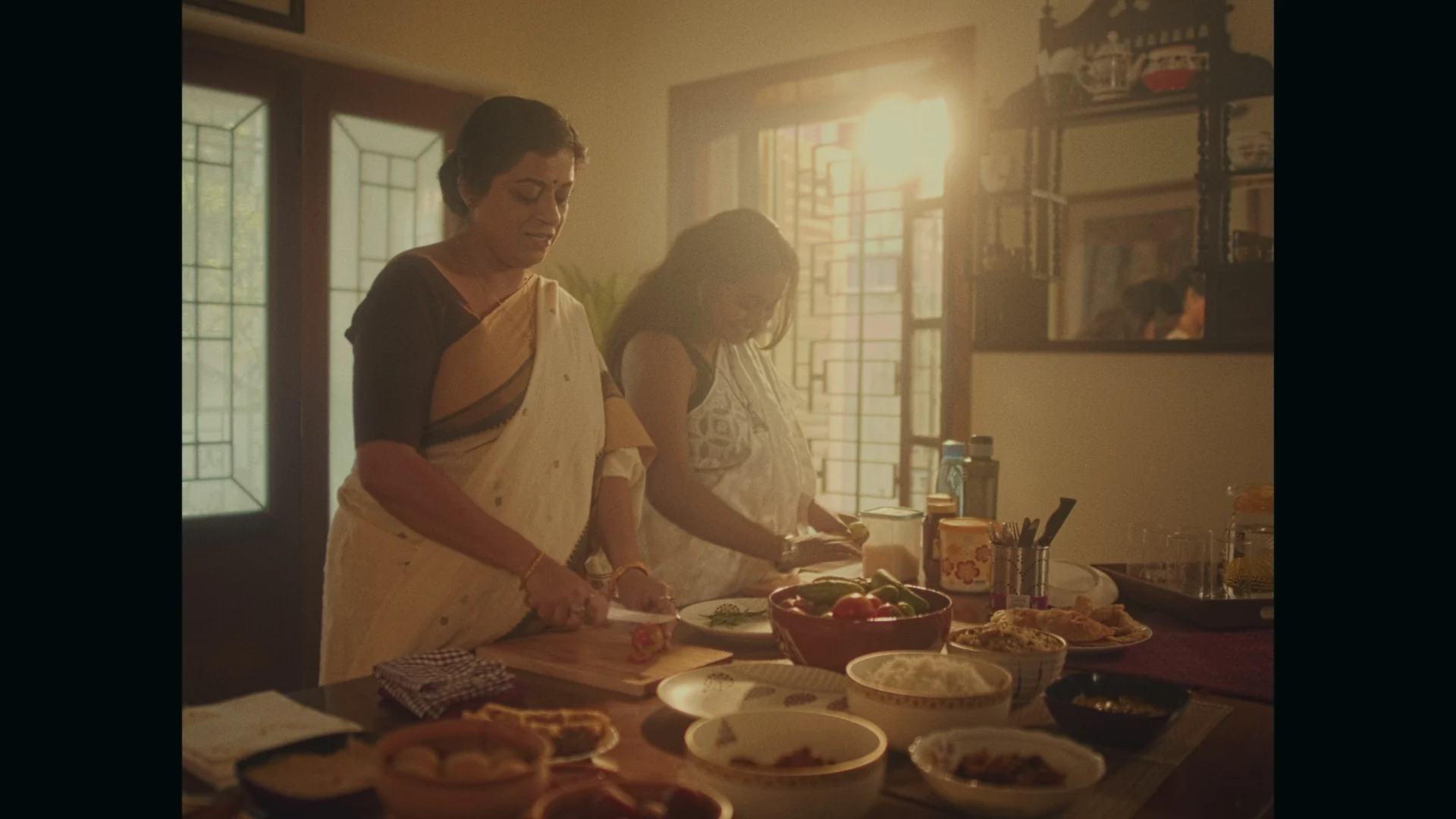 Sweet Tooth — Two women prepare food in a sunlit kitchen