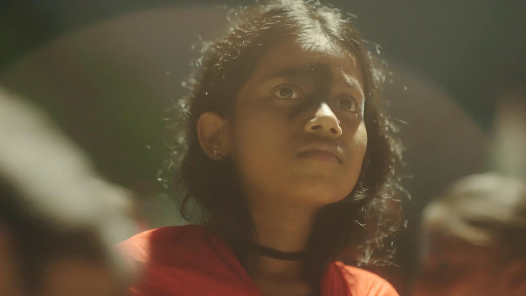 Kali — A child looks upwards in warm light